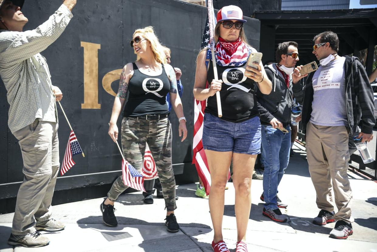 <span class="caption">QAnon demonstrators protest during a rally to reopen California and against stay-at-home directives on May 1, 2020, in San Diego. </span> <span class="attribution"><a class="link " href="https://www.gettyimages.com/detail/news-photo/conspiracy-theorist-qanon-demonstrators-protest-during-a-news-photo/1211485937?adppopup=true" rel="nofollow noopener" target="_blank" data-ylk="slk:Photo by Sandy Huffaker/AFP via Getty Images;elm:context_link;itc:0;sec:content-canvas">Photo by Sandy Huffaker/AFP via Getty Images</a></span>