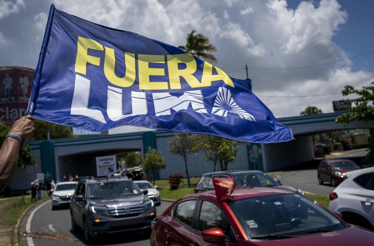 <span class="caption">A banner reads "Fuera Luma" (Luma out), opposing the company managing Puerto Rico's electric grid, at a May Day protest in San Juan on May 1, 2021.</span> <span class="attribution"><a class="link " href="https://www.gettyimages.ae/detail/news-photo/person-waves-a-flag-reading-fuera-luma-as-people-in-a-car-news-photo/1232636947" rel="nofollow noopener" target="_blank" data-ylk="slk:Ricardo Arduengo/AFP via Getty Images;elm:context_link;itc:0;sec:content-canvas">Ricardo Arduengo/AFP via Getty Images</a></span>