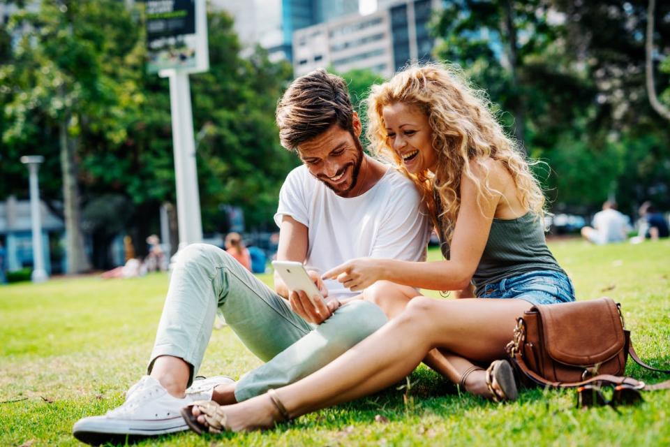 A couple laughs together in the park