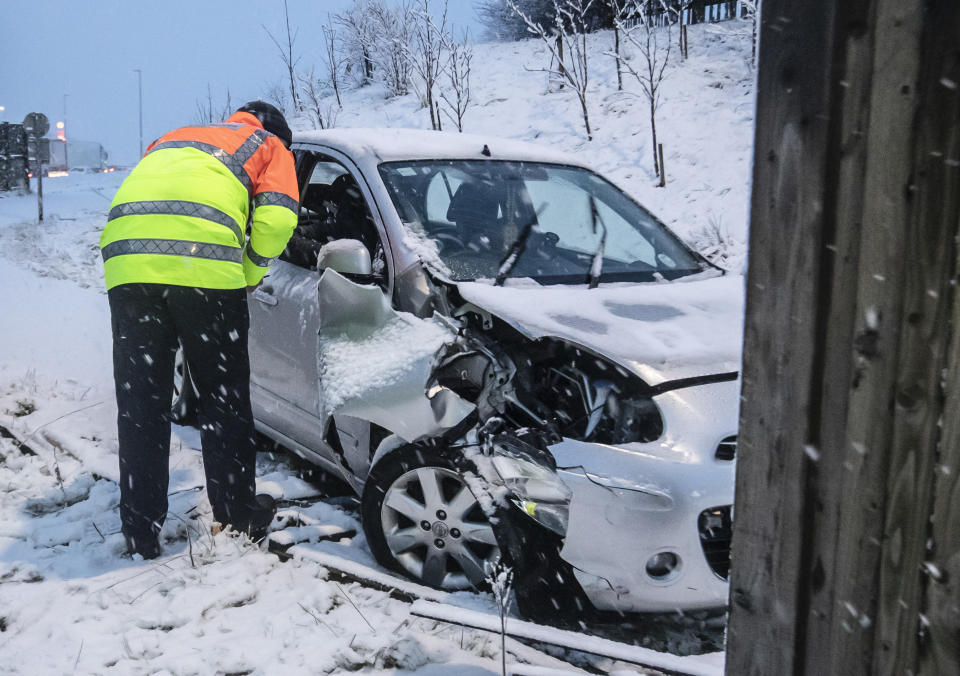 A traffic officer talks to the driver of a crashed car near Leeming Bar in North Yorkshire after overnight snow hit parts of the UK. (Photo by Danny Lawson/PA Images via Getty Images)