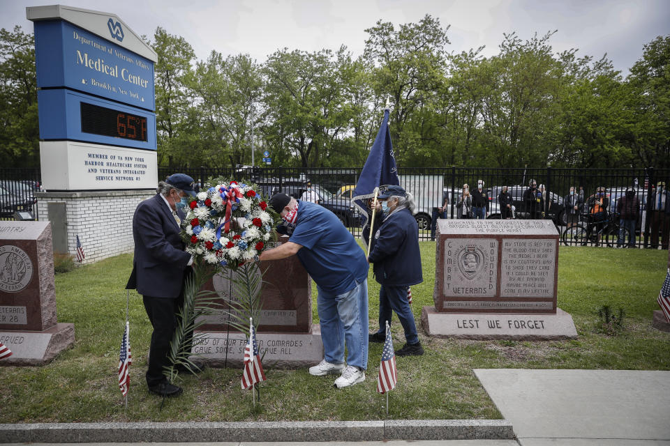 A motorcade of veterans stops outside the VA Medical Center as wreaths are laid beside memorial stones on the premises, Monday, May 25, 2020, in the Brooklyn borough of New York. (AP Photo/John Minchillo)