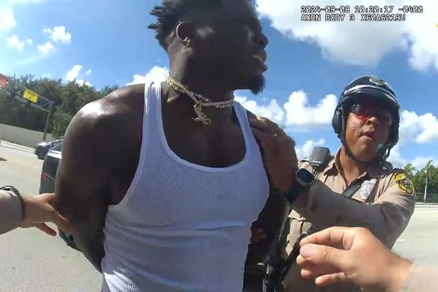 <p>Miami-Dade Police Department</p> Tyreek Hill (left) and a Miami-Dade police officer