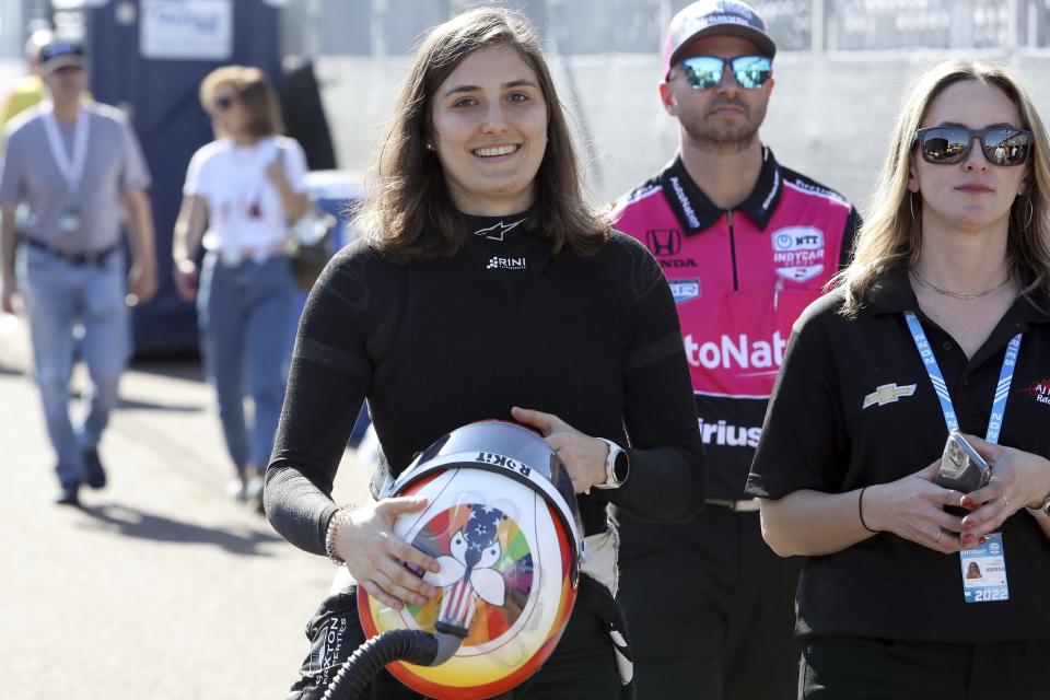 FILE - IndyCar driver Tatiana Calderon, left, chats with her team while walking to her car before the start of the IndyCar practice session at the Grand Prix of St. Petersburg auto race on Feb. 26, 2022 in St. Petersburg, Fla. Tatiana Calderon will join Simona De Silvestro in the field Sunday, June 12, 2022, to give IndyCar two women entering multiple events for the first time since 2013. (Luis Santana/Tampa Bay Times via AP, File)