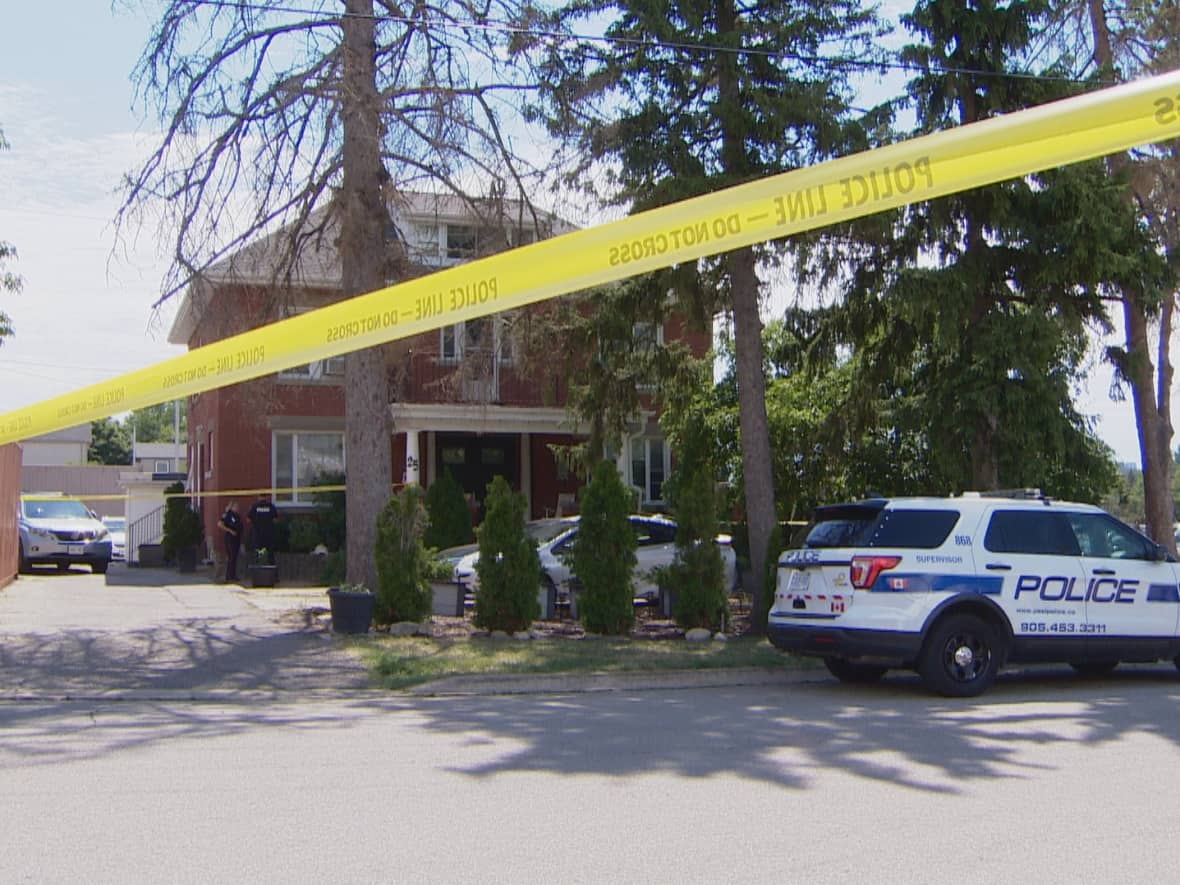 A Peel Regional Police vehicle is parked outside a home in Mississauga where police found a man and a woman dead early Tuesday. (CBC - image credit)
