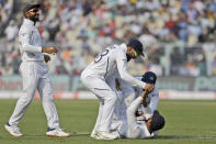 Indian cricket captain Virat Kohli, center, and other teammates congratulate Rohit Sharma, on ground, for taking a catch to dismiss Bangladesh's Mominul Haque during the first day of the second test match in Kolkata, India, Friday, Nov. 22, 2019. (AP Photo/Bikas Das)