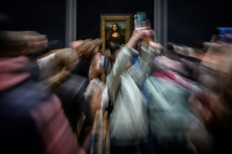 Unos visitantes fotografían el cuadro "La Gioconda" o "Mona Lisa", del artista italiano Leonardo da Vinci, en el Museo del Louvre de París, el 20 de abril de 2023 (Loic Venance)