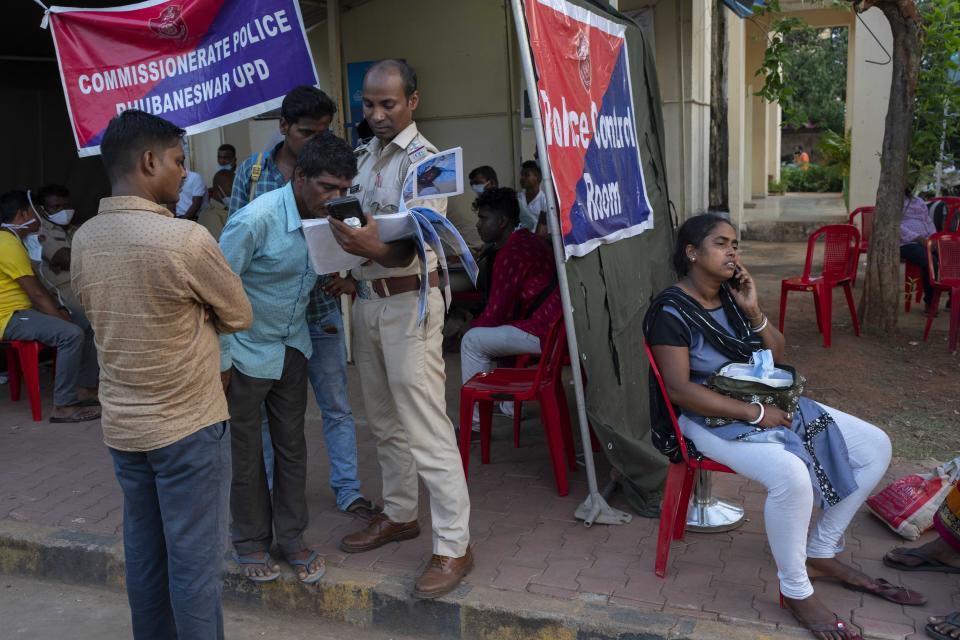 A man tries to identify his relative by looking at photographs outside a mortuary at the All India Institute of Medical Sciences hospital in Bhubaneswar in the eastern state of Orissa, India, Monday, June 5, 2023. Families of the victims of India's deadliest train crash in decades filled the hospital on Monday to identify and collect bodies of relatives, as railway officials recommended the country's premier criminal investigating agency to probe the crash that killed 275 people. (AP Photo/Rafiq Maqbool)