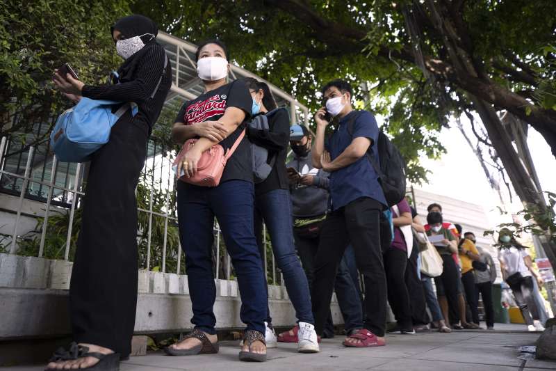 泰國民眾在社會保險辦公室外排隊申請失業救濟金。（美聯社）