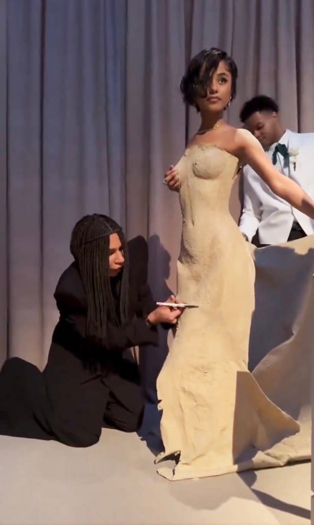 Video footage posted to Instagram shows Balmain creative director Olivier Rousteing’s craftsmanship in action, expertly cutting a new hemline for Tyla’s sand gown. LafayetteBlaack/Twitter