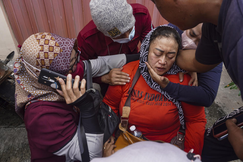 A women breaks down after receiving confirmation that her family member is among those killed in a soccer riots, at a hospital in Malang, East Java, Indonesia, Sunday, Oct. 2, 2022. Panic at an Indonesian soccer match Saturday left over 150 people dead, most of whom were trampled to death after police fired tear gas to dispel the riots. (AP Photo/Dicky Bisinglasi)