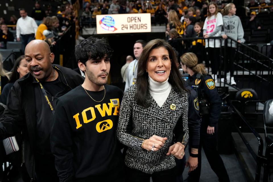Republican presidential candidate Nikki Haley arrives with her son Nalin, left, at a college basketball game between Iowa and Minnesota Saturday in Iowa City, Iowa.