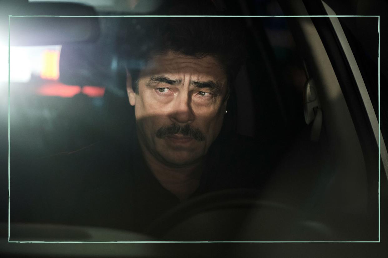  Benicio Del Toro sitting in a car as Tom Nichols in Reptile. 