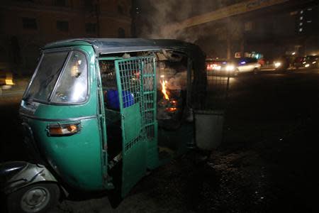 An auto rickshaw burns after being set on fire along a street in Dhaka November 25, 2013. REUTERS/Andrew Biraj