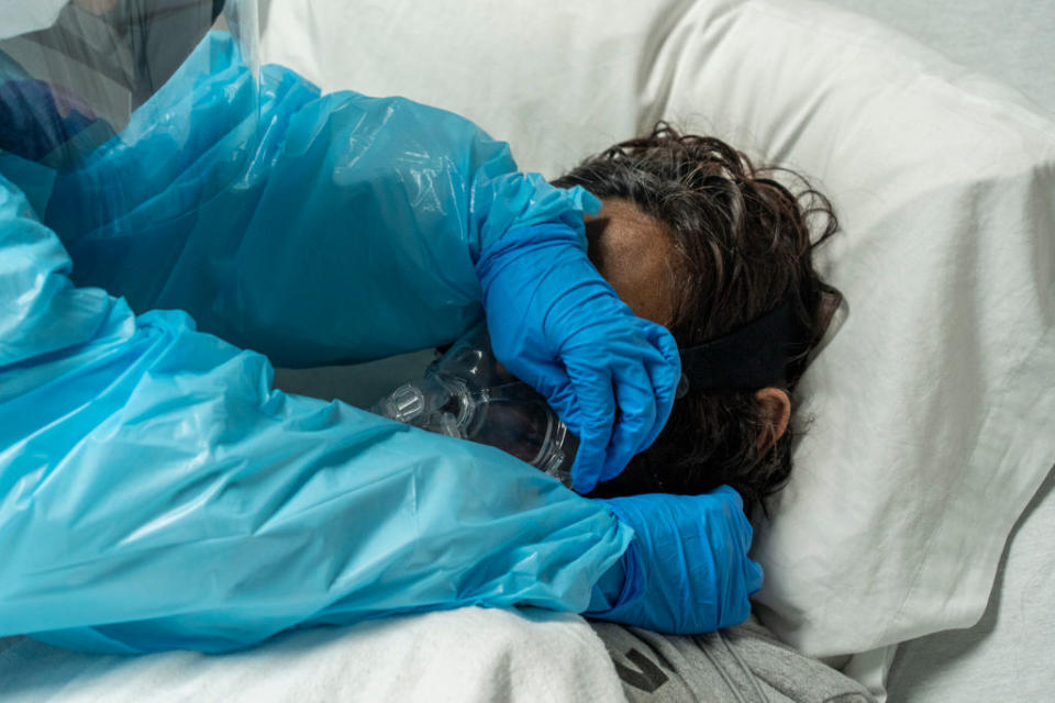 Medical staff member Mantra Nguyen installs a new oxygen mask for a patient in the COVID-19 intensive care unit (ICU) at the United Memorial Medical Center in Houston, Texas. 