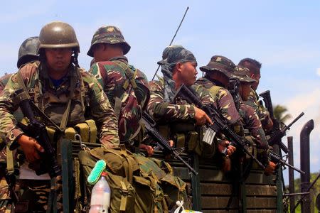 Government forces board a military truck after Islamist militants, who had holed up in a primary school, retreated after a gunbattle with troops but were holding some civilians hostage, in Pigcawayan, North Cotabato, Philippines June 21, 2017. REUTERS/Marconi Navales