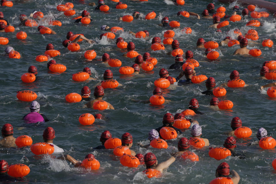 Competitors swim during a harbor race at the Victoria Harbor in Hong Kong, Sunday, Dec. 12, 2021. Hundreds of people took part in traditional swim across iconic Victoria Harbor after two years of suspension. (AP Photo/Kin Cheung)