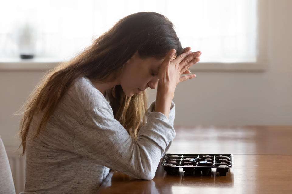 Girl sit at table with box of chocolates. Photo: Getty Images