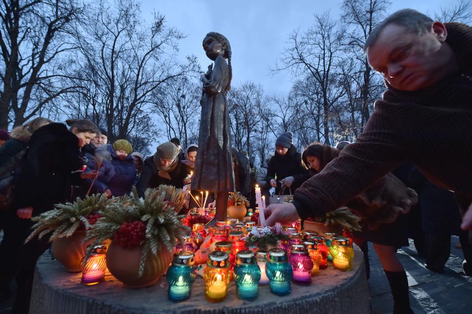 People place candles in memory of the victims of the Holodomor famine during a ceremony at the Holodomor memorial in Kiev on November 22, 2014. Ukraine marked 81 years since the Stalin-era Holodomor famine, one of the darkest pages in its entire history that left millions dead and which is regarded by many as a genocide. The 1932-33 famine took place as harvests dwindled and Soviet leader Josef Stalin's police enforced the brutal policy of collectivising agriculture by requisitioning grain and other foodstuffs.