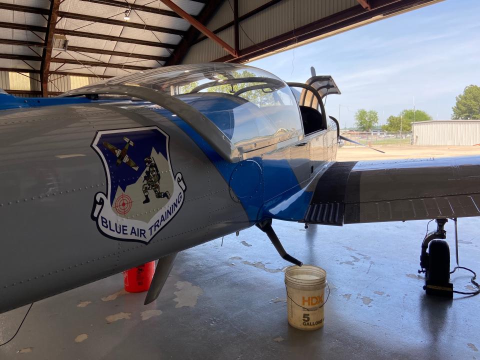 Blue Air Training logo on the side of a plane inside the hangar.