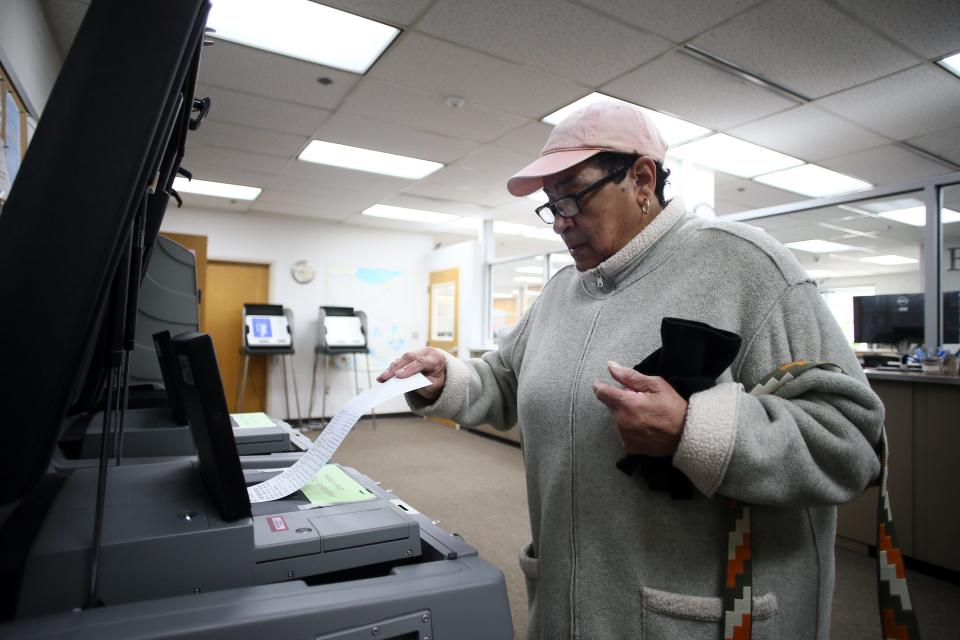 Alex Mitchell, of Newark, submits her completed ballot after voting early Wednesday at the Licking County Board of Elections office in Newark.