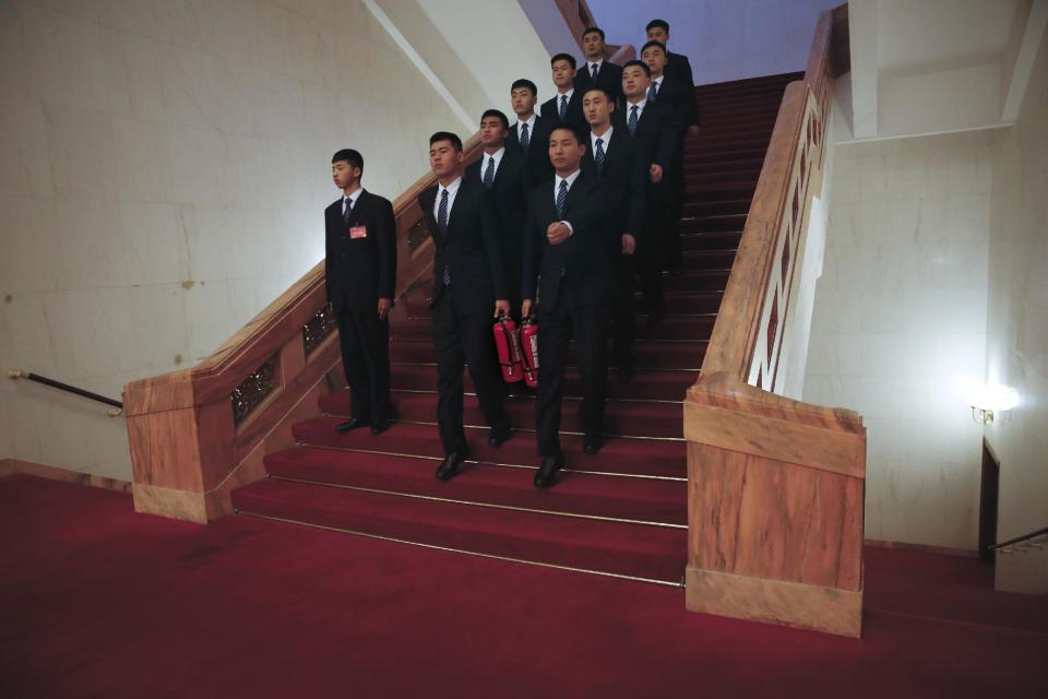 In this Friday, March 10, 2017 photo, soldiers in usher uniforms, some carry fire extinguishers march down a staircase after the Chinese People's Political Consultative Conference (CPPCC) at the Great Hall of the People in Beijing. Because safety comes first, fire extinguishers are ubiquitous in and around Beijing’s Great Hall of the People during the annual sessions of China’s ceremonial parliament and its official advisory body. That’s partly for standard purposes of preventing any sort of fire-related emergency that could harm the participants and mar the proceedings. (AP Photo/Andy Wong)