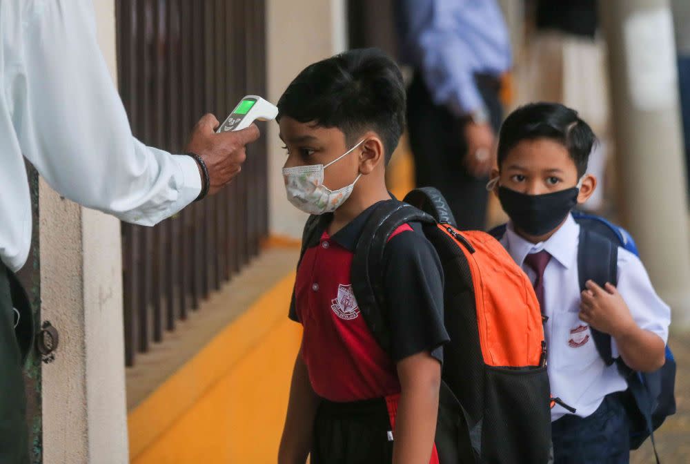 A student has his temperature checked at Sekolah Kebangsaan Cator Avenue, Ipoh as schools reopen March 1, 2021. — Picture by Farhan Najib