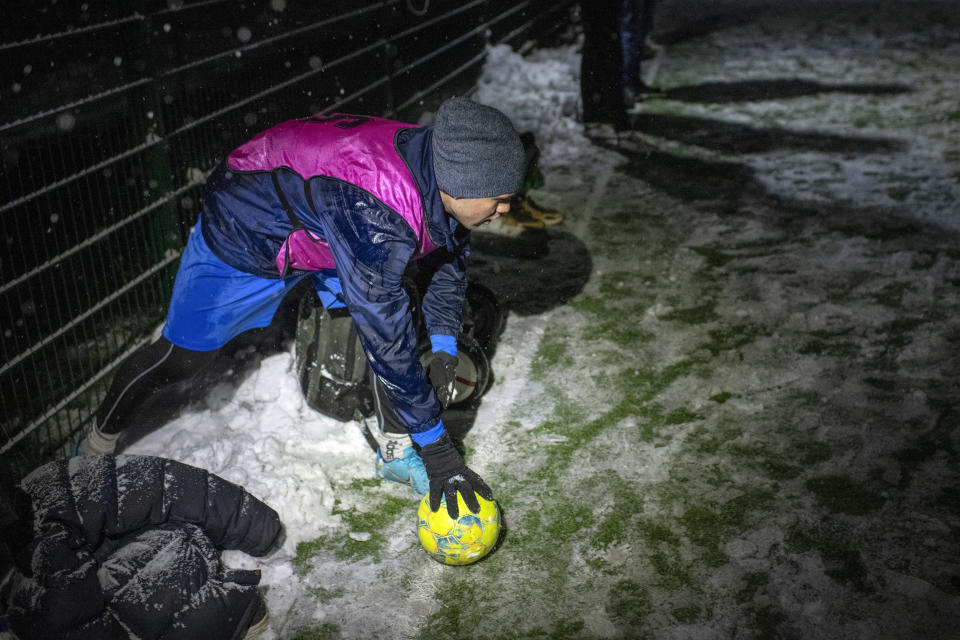 A player prepares for a soccer game during a blackout in Irpin, Kyiv region, Ukraine, Tuesday, Nov. 29, 2022. For soccer lovers in Ukraine, Russia's invasion and the devastation it has wrought have created uncertainties about both playing the sport and watching it. For Ukrainians these days, soccer trails well behind mere survival in the order of priorities. (AP Photo/Andrew Kravchenko)