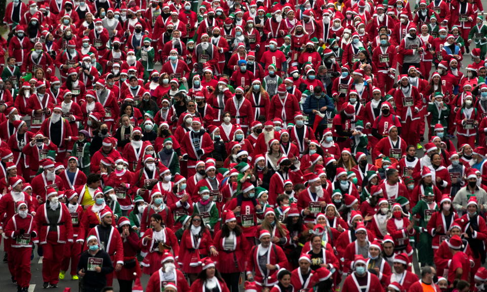 People wearing Santa Claus outfits take part in a charity race to collect funds to help victims of the Cumbre Vieja volcano eruption in Madrid, Spain, December 19, 2021. REUTERS/Juan Medina