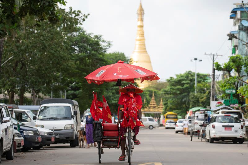 Trishaw drives by a pagoda while campaigns for the National League for Democracy in Yangon