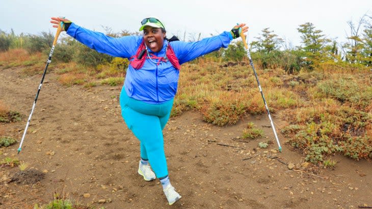 Mirna in a blue runners outfit with a red pack on running a race