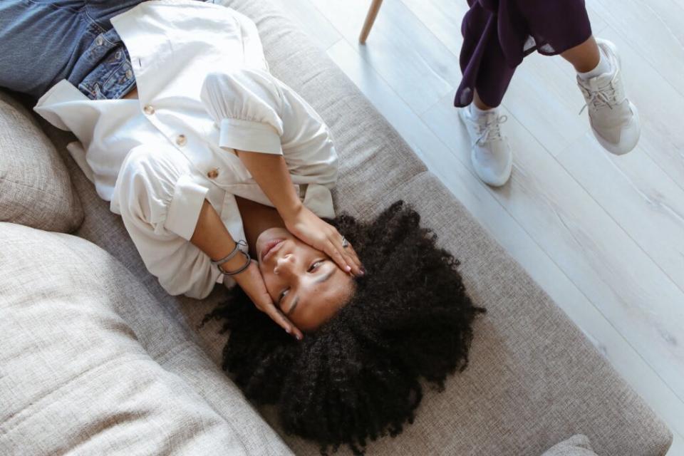 Visibly distressed Black women talking to her therapist as she lays on the couch