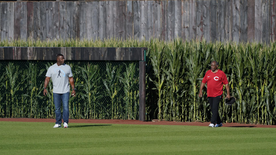 Ken Griffey Jr., left, and his father Jen Griffey Sr., walk on to the field before a baseball game between the Cincinnati Reds and Chicago Cubs at the Field of Dreams movie site, Thursday, Aug. 11, 2022, in Dyersville, Iowa. (AP Photo/Charlie Neibergall)