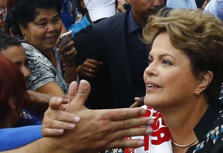 Brazil's President and Workers' Party (PT) presidential candidate Dilma Rousseff greets her supporters during a campaign rally in Duque de Caxias near Rio de Janeiro October 22, 2014. REUTERS/Ricardo Moraes