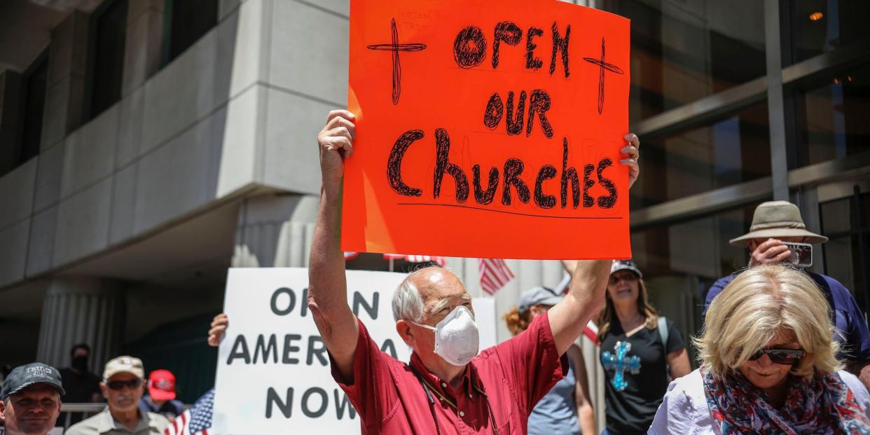 Demonstrators holding signs demanding their church to reopen, protest during a rally to re open California and against Stay At Home directives on May 1, 2020 in San Diego, California.