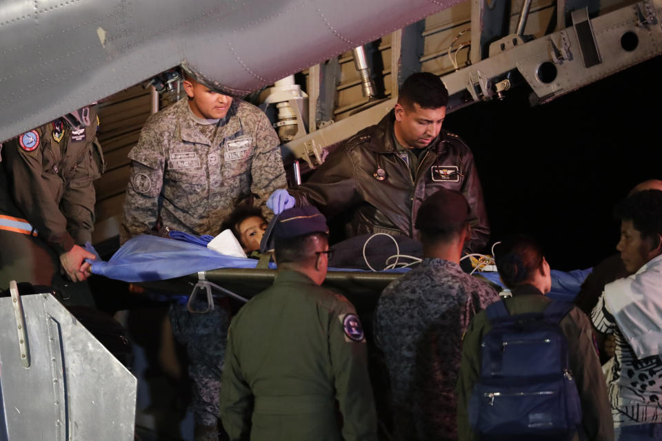 Personal militar saca de un avión a uno de los cuatro niños indígenas que estaban desaparecidos después de un accidente aéreo mortal en la base aérea militar de Bogotá, Colombia, el sábado 10 de junio de 2023. Los niños sobrevivieron a un accidente de avión pequeño hace 40 días y habían sido objeto de una intensa búsqueda en la selva. (Foto AP/Iván Valencia)