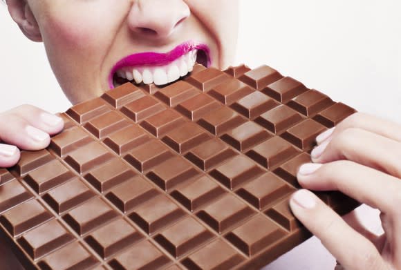 Woman biting a block of chocolate