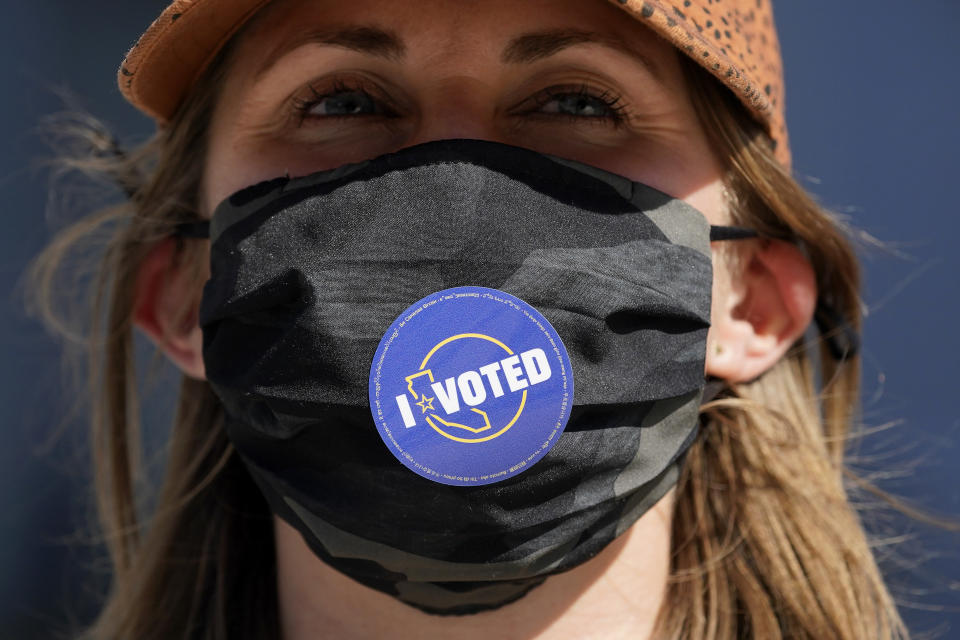 Lillian Lauer wears an I Voted sticker on her face mask after dropping off her ballot at a San Francisco Department of Elections drop-off location at the Chase Center in San Francisco, Monday, Nov. 2, 2020, ahead of Election Day. (AP Photo/Jeff Chiu)