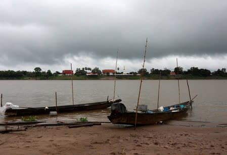 Pagoda from Laos is seen under a rain cloud from across the Mekong River in Nakhon Phanom