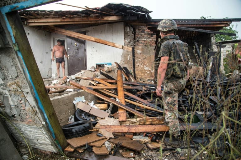 A Ukrainian serviceman examines a destroyed house after shells hit Zolote, 60 km west of Lugansk, on August 16, 2015