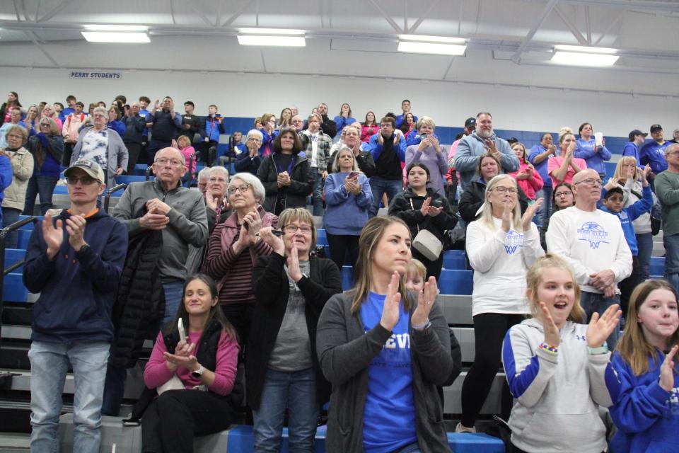 Perry community members cheer after a check was given to the Perry Booster Club from the Iowa Wolves during a basketball doubleheader against Greene County on Tuesday, Feb. 6, 2024, at Perry High School.