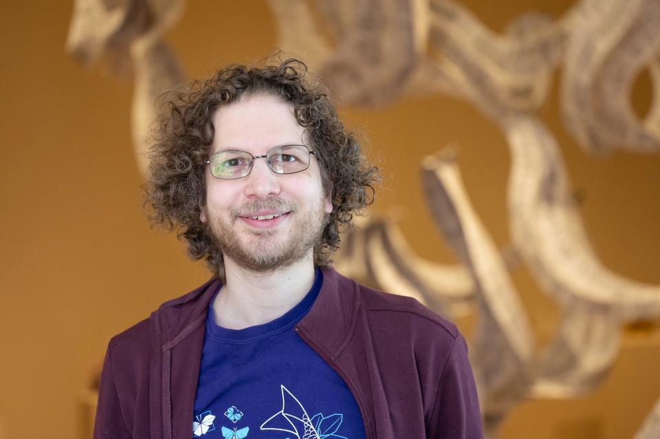 Eric Demaine poses in front of his piece, Hanging Out 2023, currently on display as part of "Paper Town" at Fitchburg Art Museum on Sunday April 02, 2023.