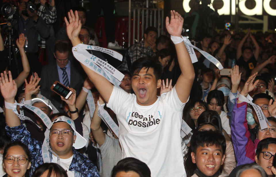 Supporters of Taipei city mayor and city mayoral candidate Ko Wen-je cheer for Ko's victory in Taipei, Taiwan, Sunday early morning, Nov. 25, 2018. Taiwan's ruling party suffered a major defeat Saturday in local elections seen as a referendum on the administration of the island's independence-leaning president amid growing economic and political pressure from China. (AP Photo/Chiang Ying-ying)