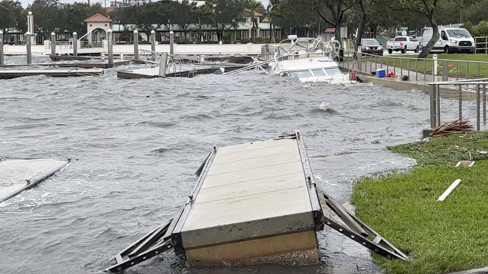 A submerged boat bangs against the seawall and pontoon piers at Lee Wenner Park in Cocoa Village on Thursday following Tropical Storm Nicole.