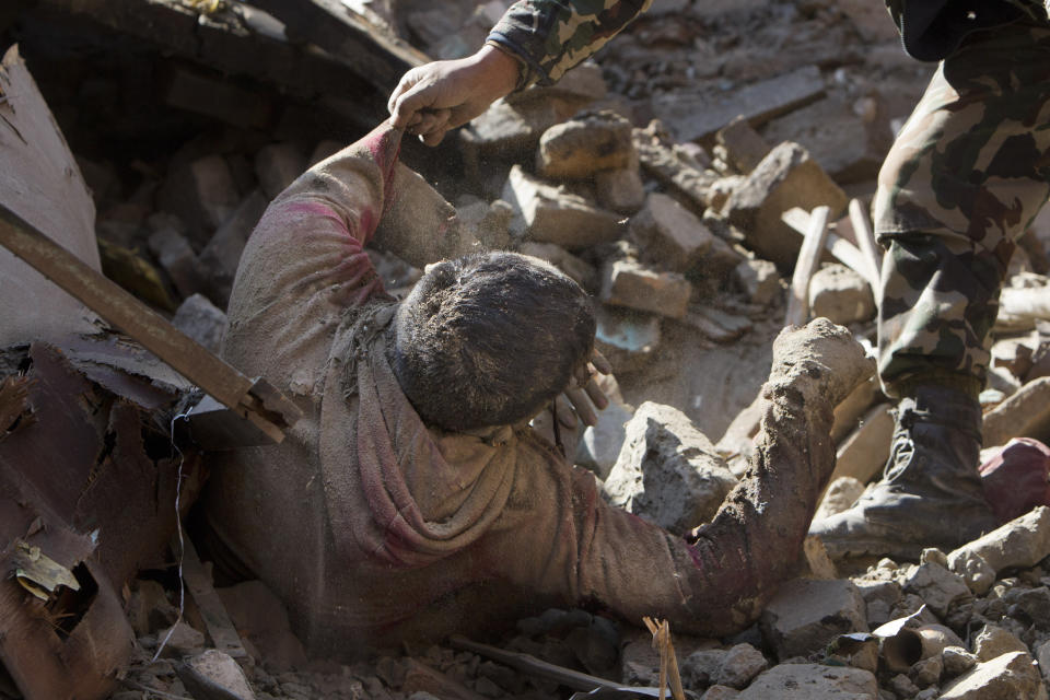 Members of Nepalese army rescue a dead body from inside a building that collapsed in Saturday's earthquake, in Bhaktapur, on the outskirts of Kathmandu, Nepal, Monday, April 27, 2015.  (AP Photo/Niranjan Shrestha)