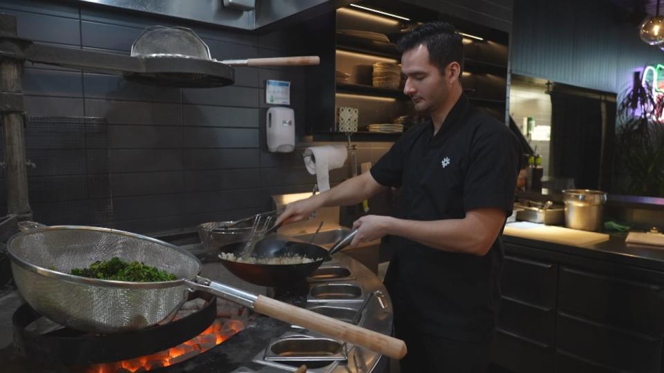 Luis Avila, the head chef at Chotto Matte, is seen preparing food over the robata grill in the restaurant. 