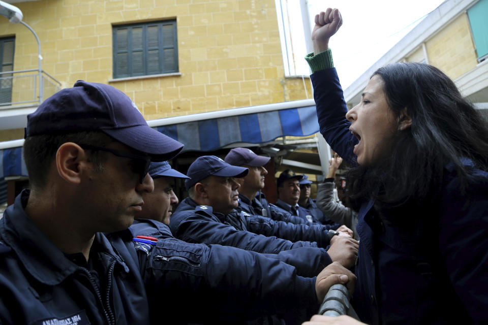 A Greek Cypriot protestor shouts slogans towards the police, during a demonstration against the closing of a crossing point straddling a United Nations-controlled buffer zone in divided capital Nicosia, Cyprus, Saturday, Feb. 29, 2020. Around 200 people gathered at the Ledra Street crossing point to voice their opposition to its closing. The Cyprus government said it closed the Ledra Street crossing point along with three others to help with efforts to prevent the possible spread of a new COVID-19 virus either to the breakaway, Turkish Cypriot north or the internationally recognized, Greek Cypriot south. (AP Photo/Petros Karadjias)