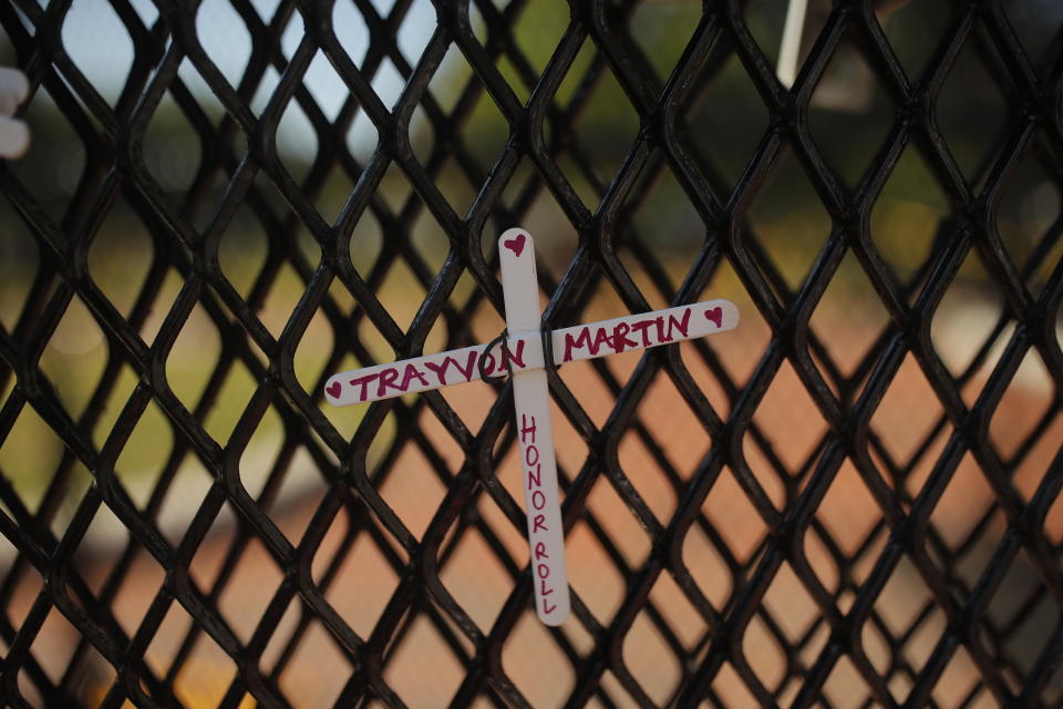 FILE - A cross with Trayvon Martin's name is tied to a fence near the White House as demonstrators protest, June 7, 2020, near the White House in Washington over the death of George Floyd, a Black man who was in police custody in Minneapolis. Gunned down in a Florida gated community where his father lived in 2012, Martin was one of the earliest symbols of the Black Lives Matter movement that now wields influence in politics, law enforcement and broader conversations about racial progress in and outside the U.S. (AP Photo/Maya Alleruzzo, File)