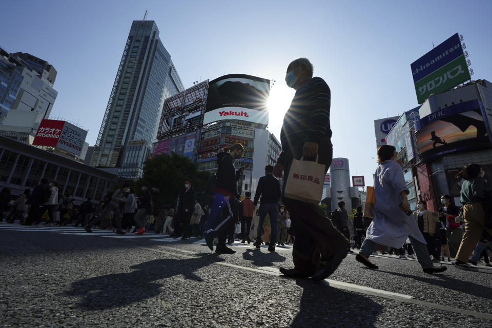 People wearing protective masks to help curb the spread of the coronavirus walk along a pedestrian crossing in Shibuya district in Tokyo on April 7, 2021. Japan is set to strengthen anti-virus measures in Tokyo on Friday, April 9, 2021 to curb the rapid spread of a more contagious coronavirus variant just three months before the Olympics begin in the capital where most people are not yet vaccinated. (AP Photo/Eugene Hoshiko)