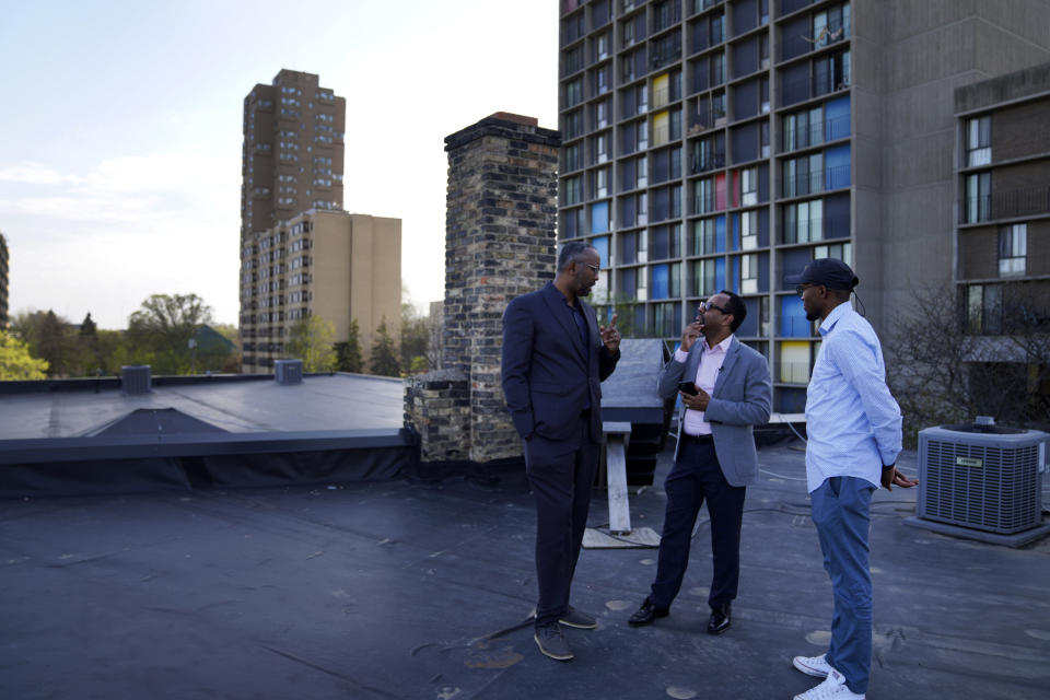 Jaylani Hussein, executive director of the Minnesota chapter of the Council on American-Islamic Relations, left, and Wali Dirie, executive director of the Islamic Civic Society of America Dar Al-Hijrah mosque, center, talk on the roof of Dar Al-Hijrah, where the call to prayer, or adhan, is publicly broadcast, on Thursday, May 12, 2022, in Minneapolis. (AP Photo/Jessie Wardarski)