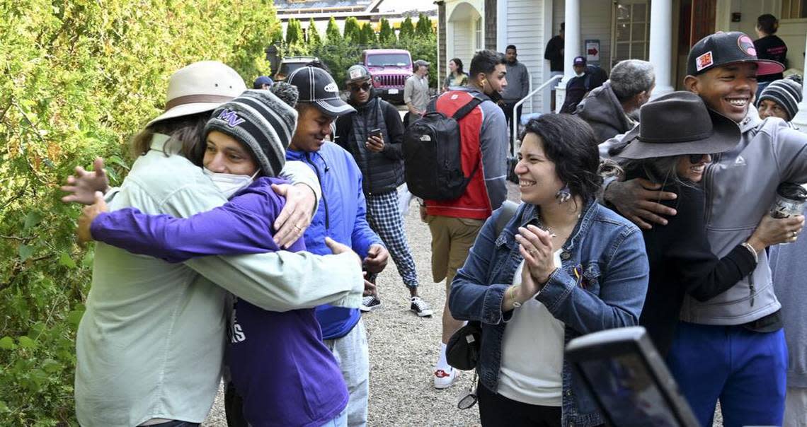 Carlos Munoz hugs Larkin Stallings, of Vineyard Haven, Massachusetts, as he and other immigrants prepare to leave Edgartown on Martha’s Vineyard.